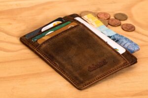 Wallet with card and coins on a desk