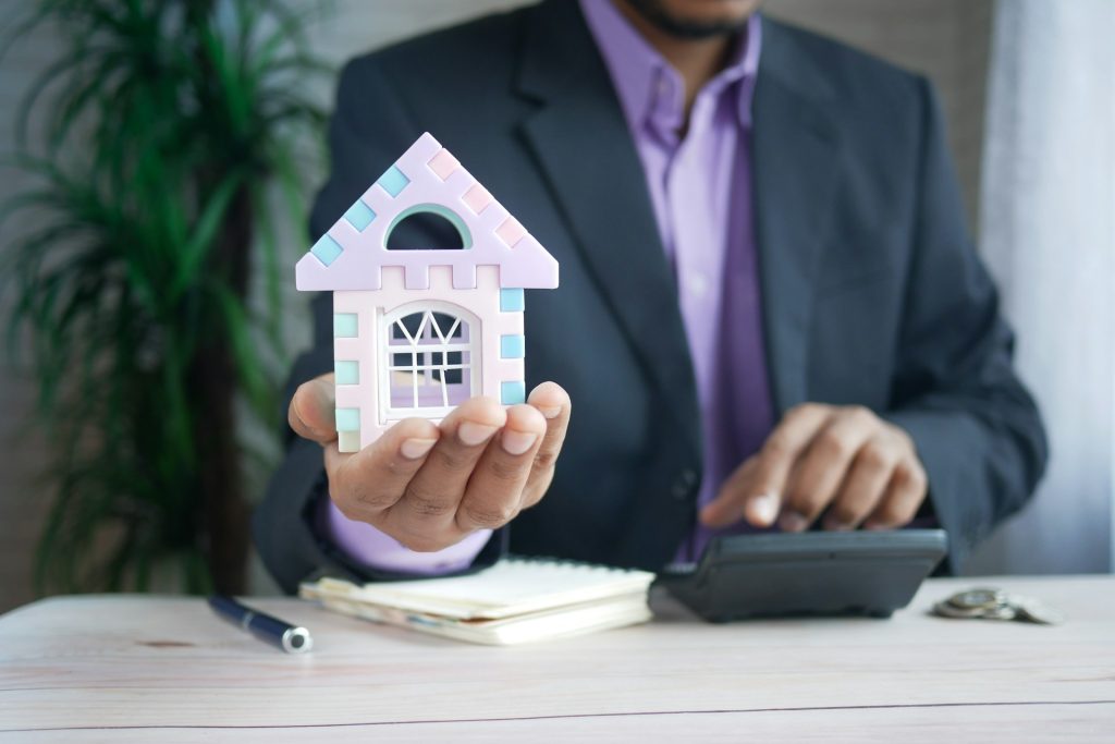 a real estate agent holding a house model