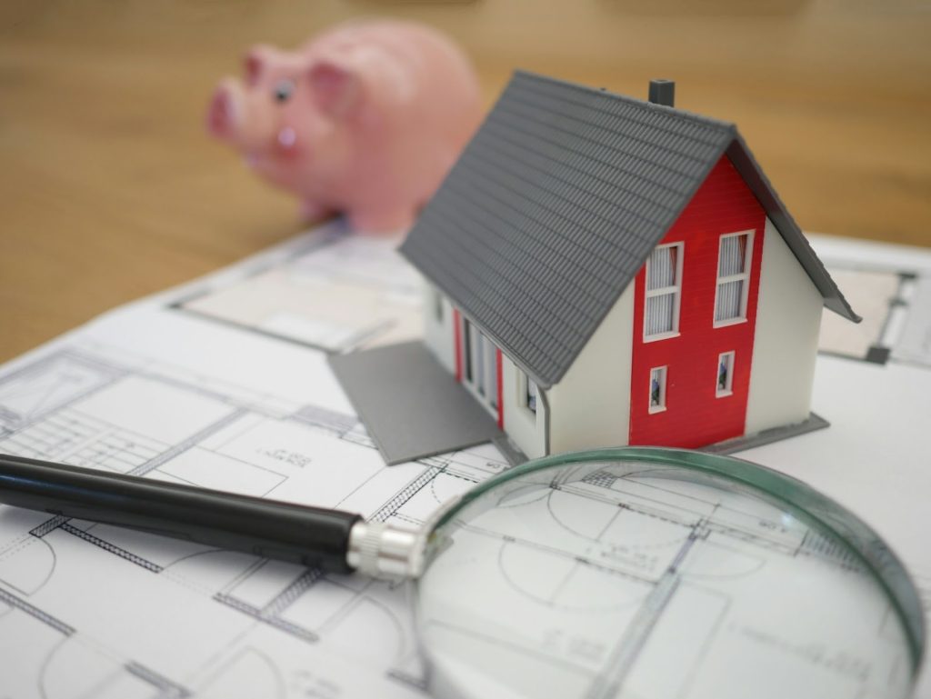 a house model and a magnifying glass