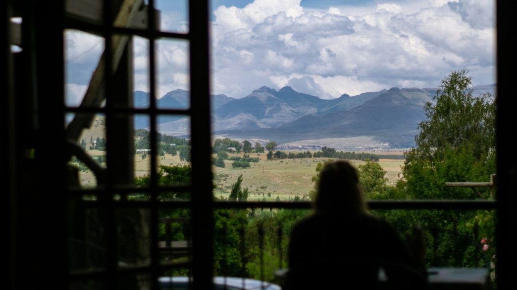 a person sitting and looking at mountains