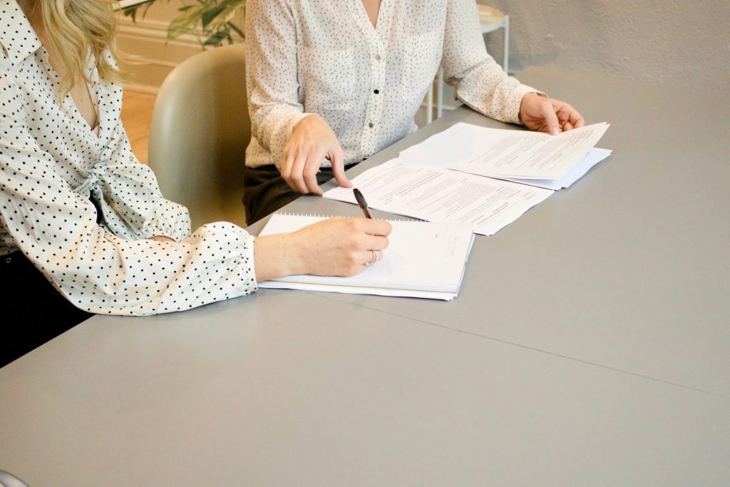 two people signing documents