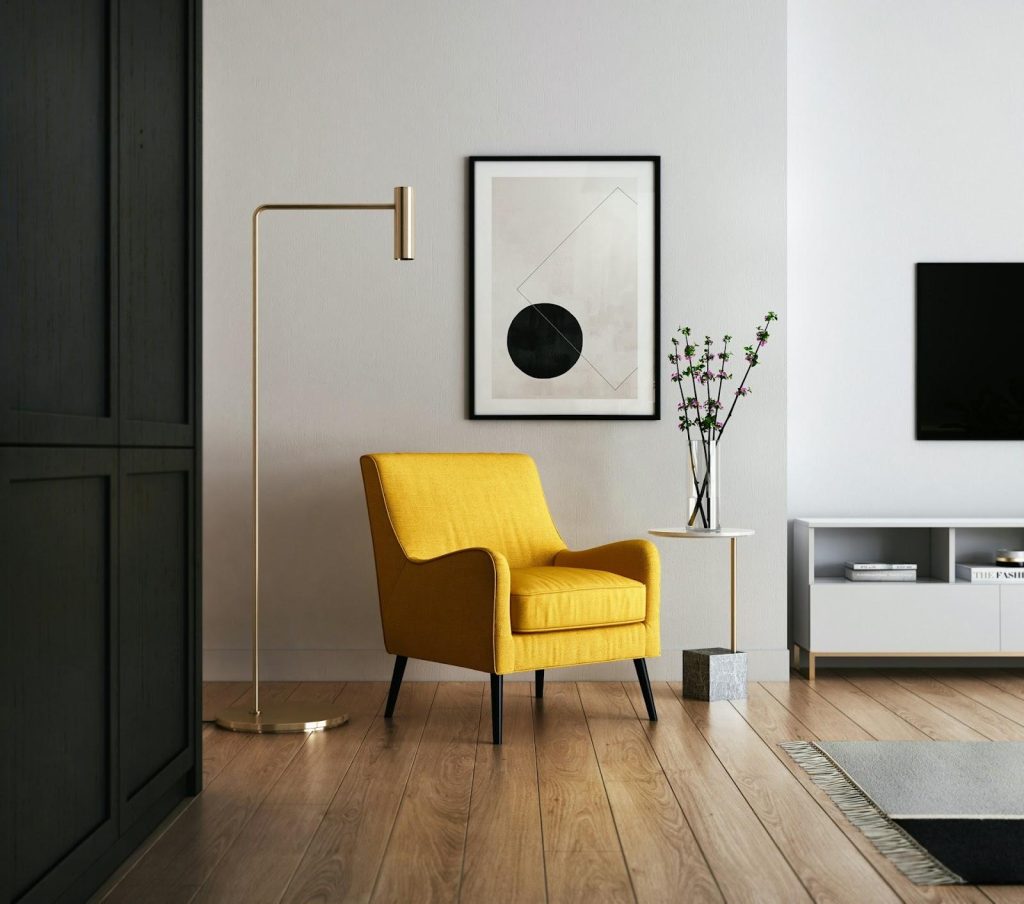 a yellow armchair and a painting on a wall