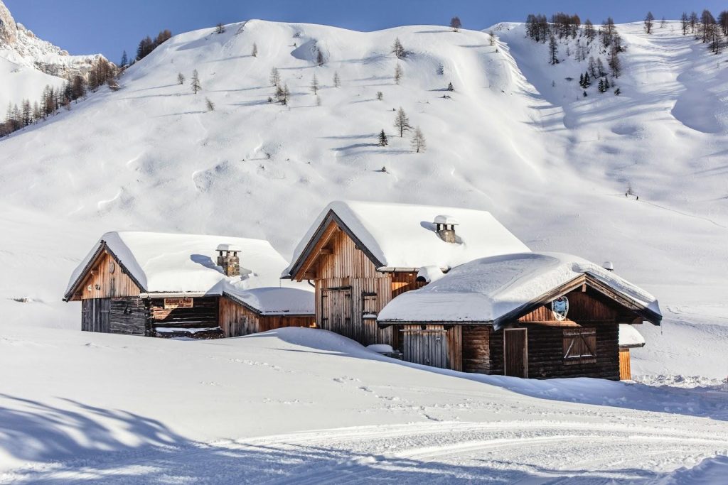 three wooden houses on a snowy mountain