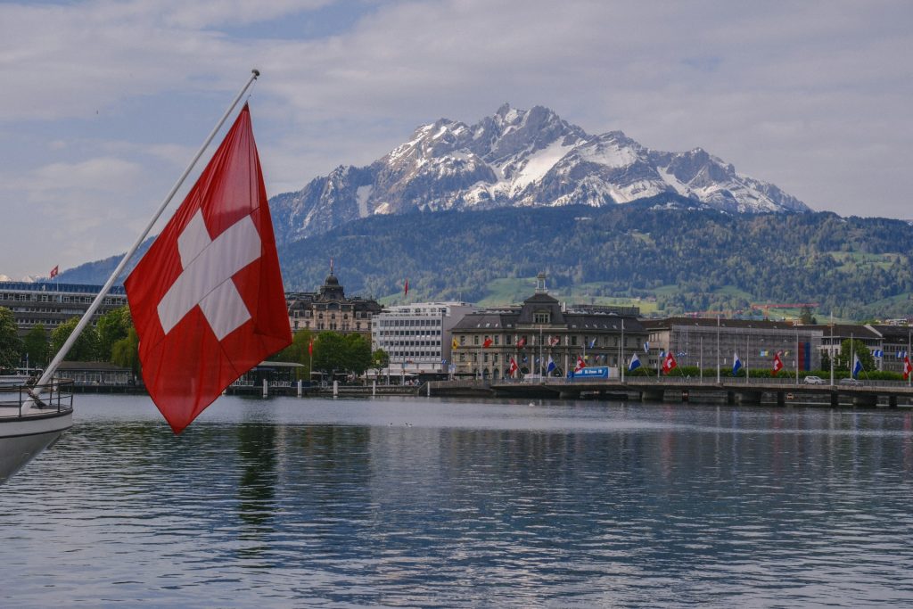 a Swiss flag on a lake