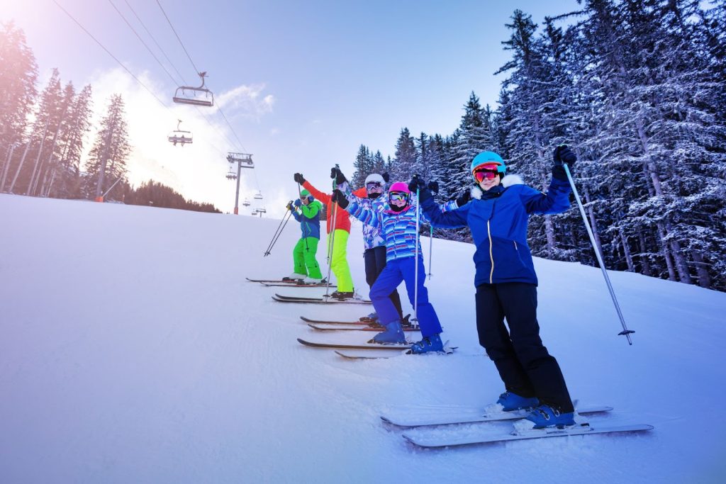 five skiers standing on a piste