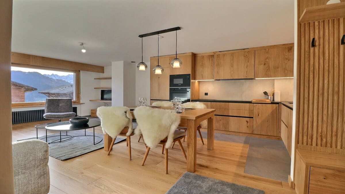 Intérieur d'un salon de chalet élégant avec poutres apparentes et vue sur les Alpes